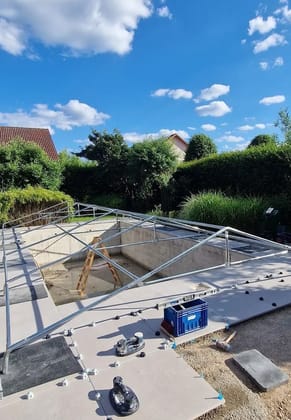 Poolbecken mit Poolabdeckung im Aufbau, Feinarbeit am Beckenrand