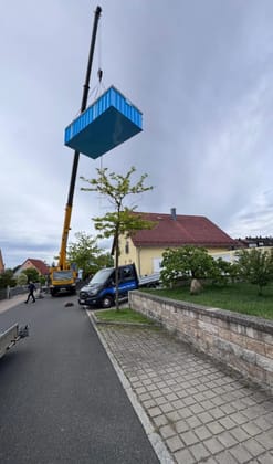 Poolbecken wird per Kran über eine Wohnstraße bei Regensburg eingehoben