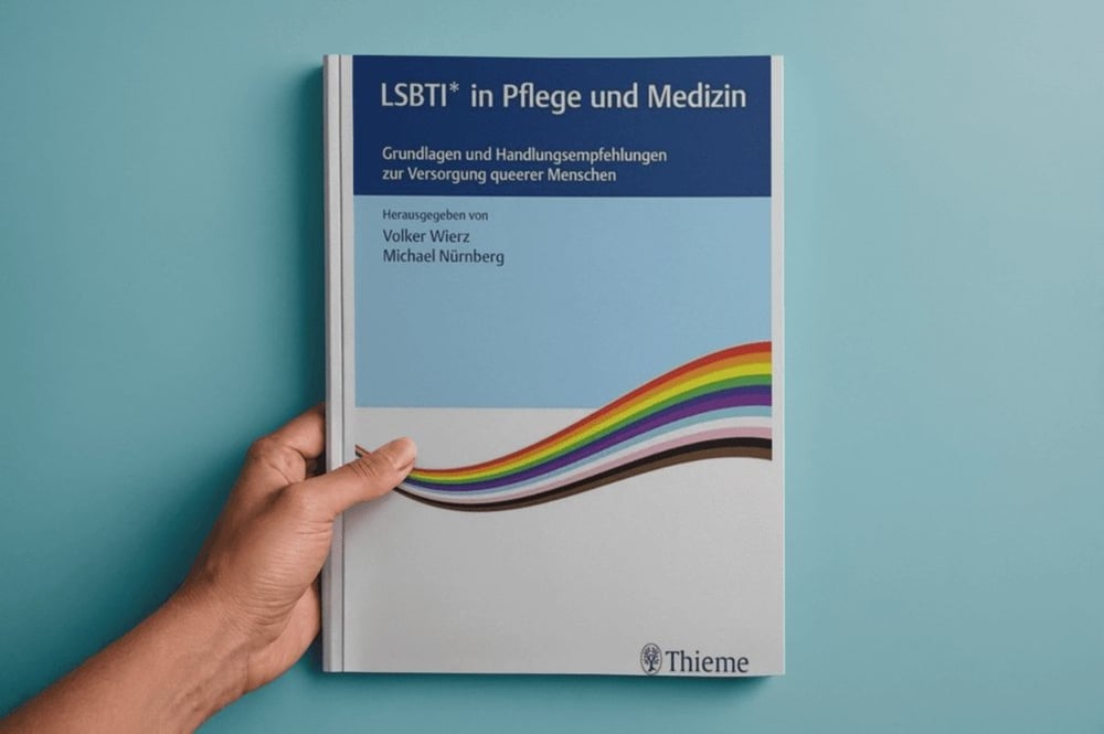 Hände halten das Fachbuch LSBTI in Pflege und Medizin.