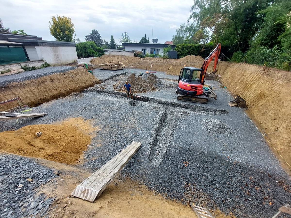 Erdarbeiten und Planum mit Bagger auf einem Baugrundstück