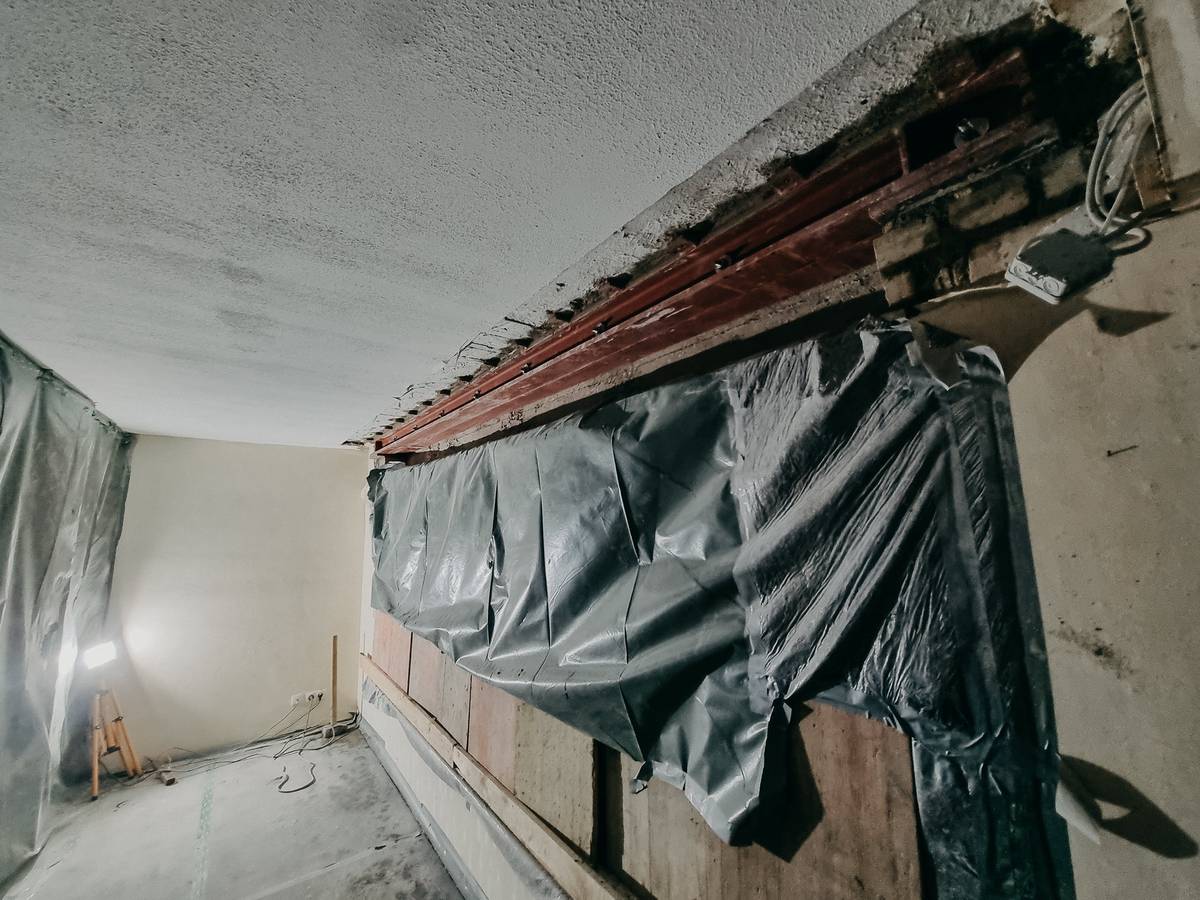 Wanddurchbruch mit neuem Stahlträger und Staubschutzfolie in einem Wohnhaus