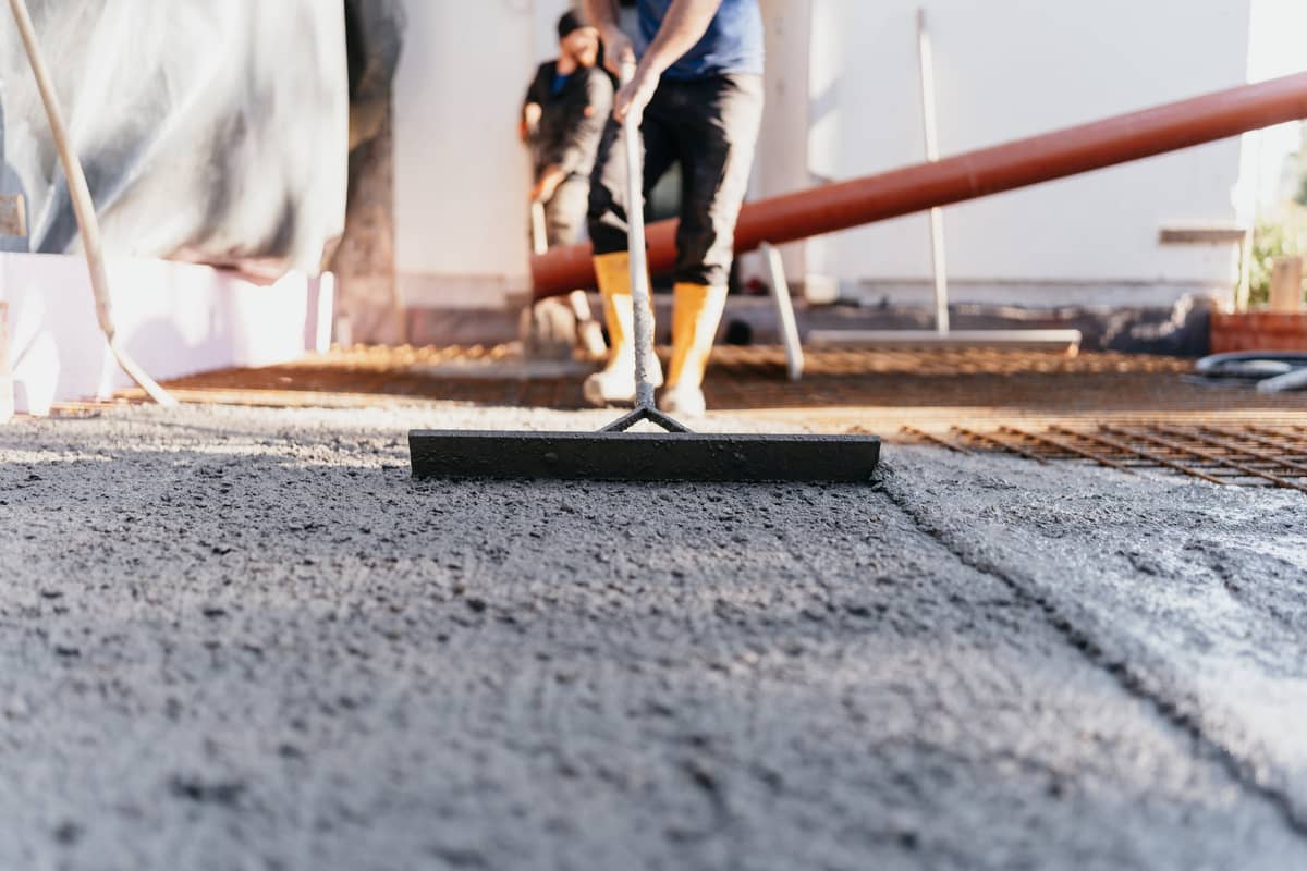 Frischer Beton wird mit der Abziehlatte geglättet