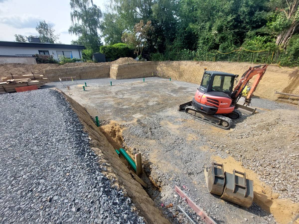 Bagger hebt eine Baugrube für ein Wohnhaus aus