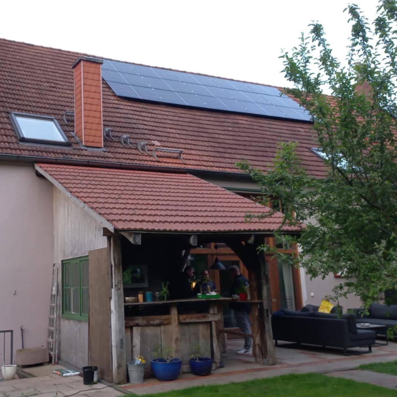 Garage und Klinkerhaus mit Solarmodulen auf dem Ziegeldach