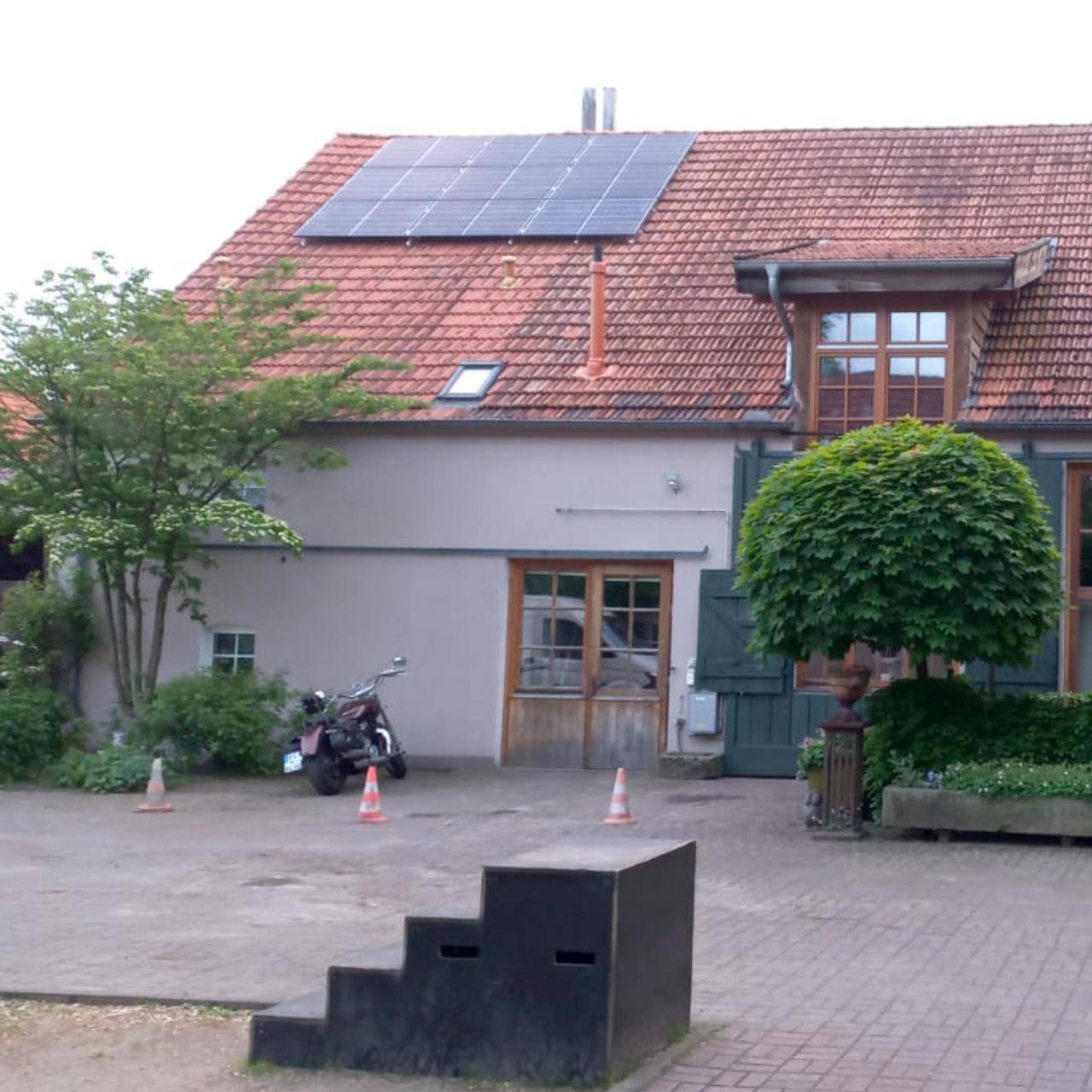 Hof mit rotem Ziegeldach und Solarmodulen