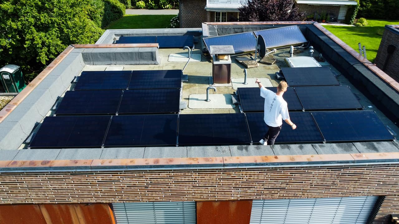 Flachdach mit schwarzen Solarmodulen aus der Drohnenperspektive