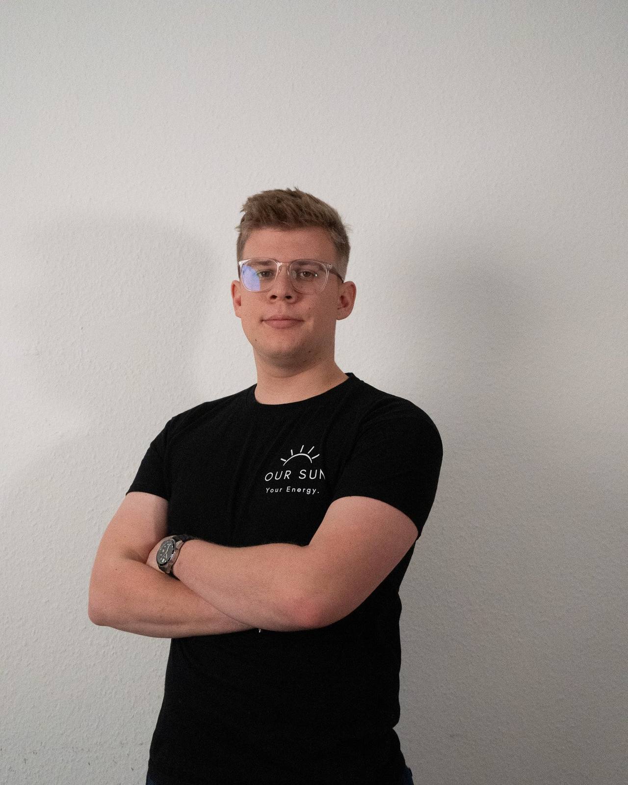 Jona Pakebusch, Geschäftsführer von OurSun Solar, im Firmen-Shirt mit verschränkten Armen