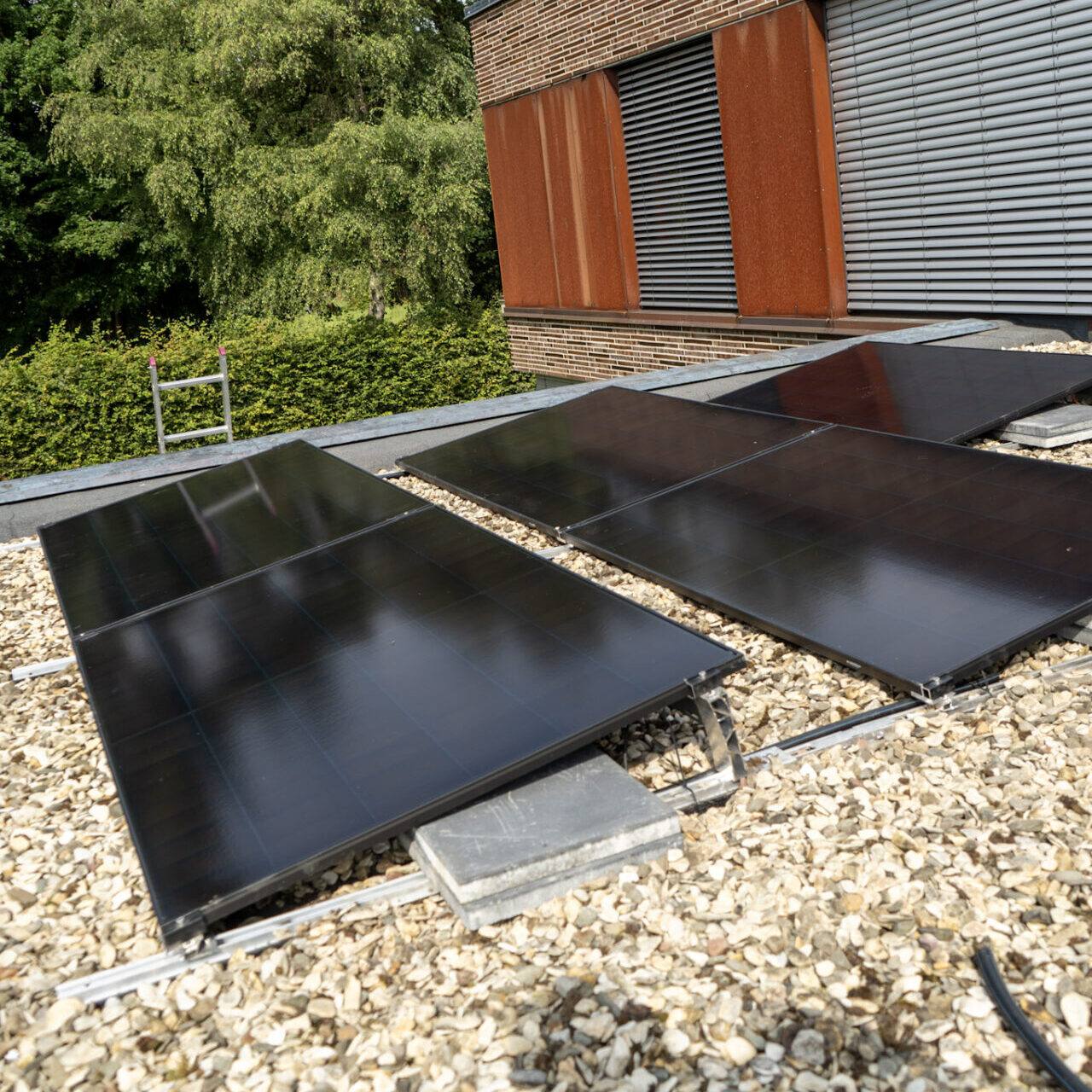 Flachdach mit Kies und Solarmodulen in Nahaufnahme