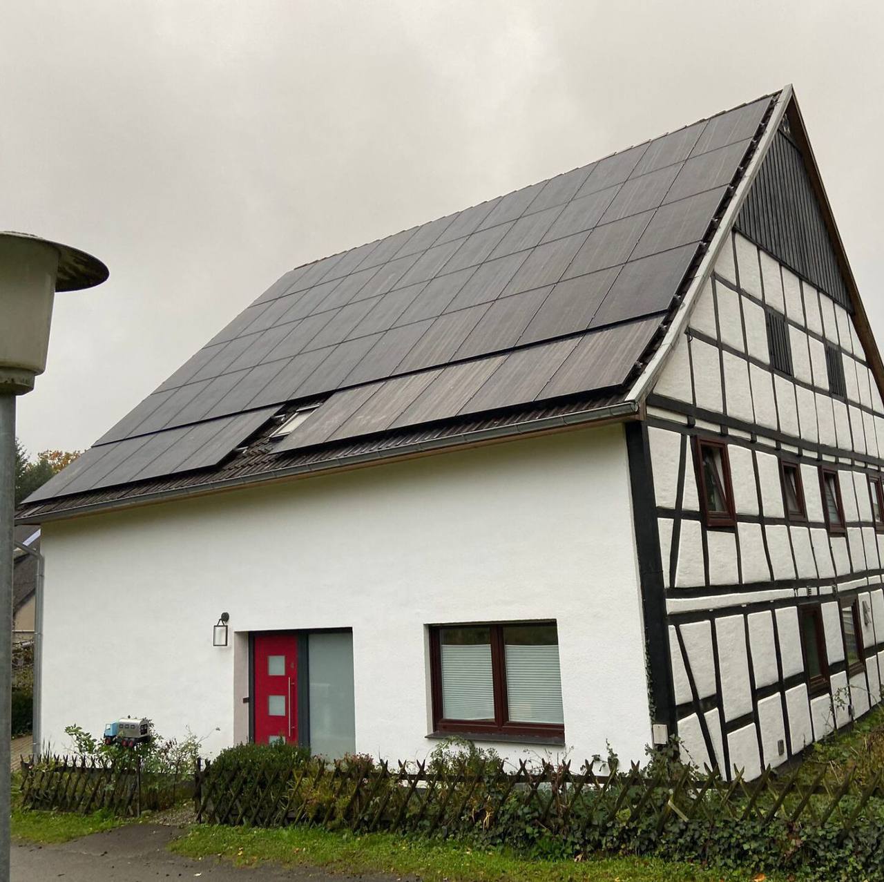 Fachwerkhaus mit vollschwarzen Solarmodulen auf dem Dach