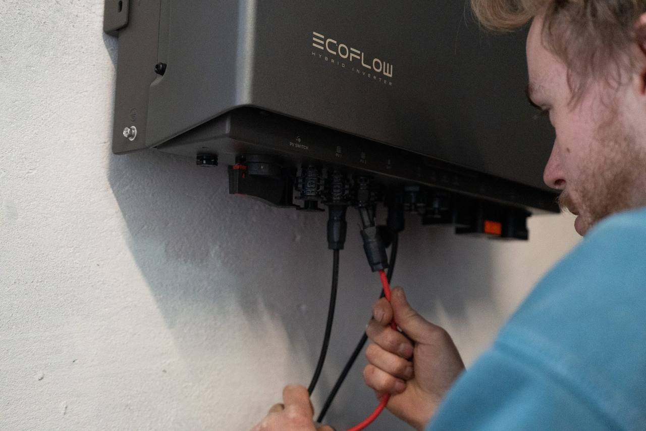 Techniker verkabelt einen Hybrid-Wechselrichter mit Stromspeicher