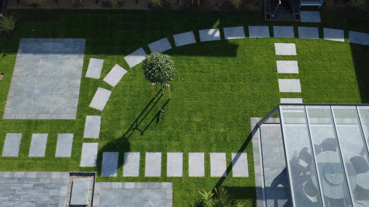 Gartenneuanlage mit Rollrasen, Trittplatten und Terrasse unter Glasdach in Polch