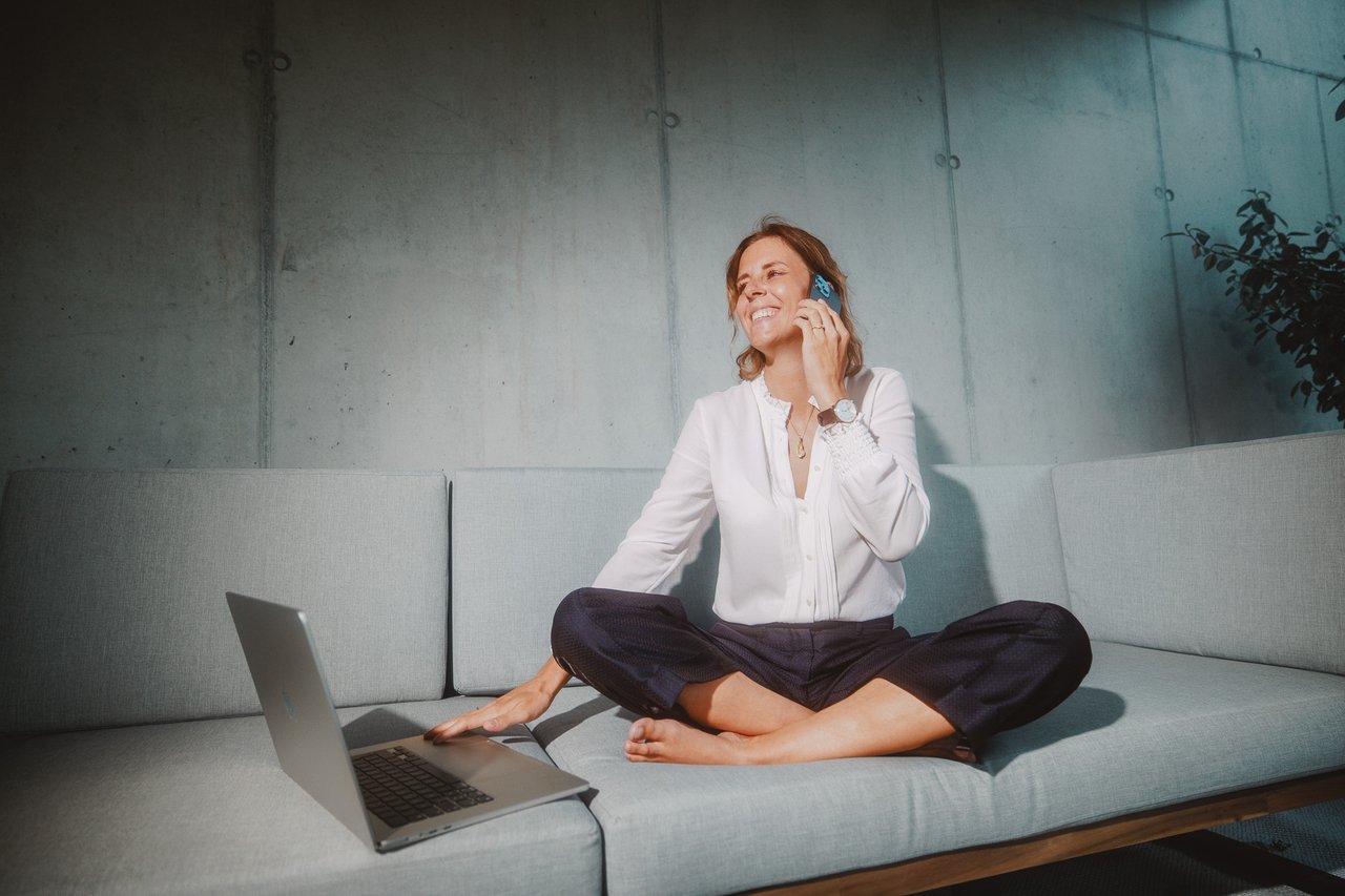 Steffi Furrer mit Telefon und Laptop im Studio