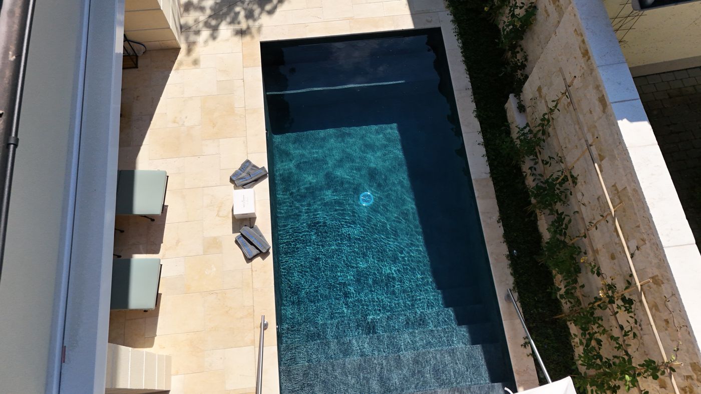 Luftaufnahme des 7 × 3 m großen Pools zwischen Haus und Mauer mit Einstiegstreppe