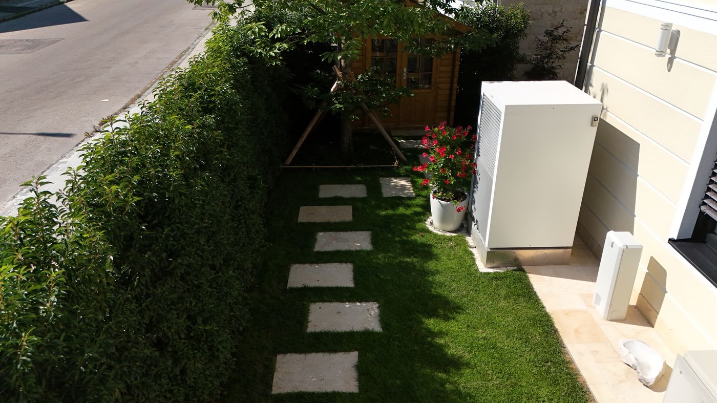 Gartenbereich mit Rasen, Trittplatten und Hecke, Außenanlage geplant von Hanschke GalaBau