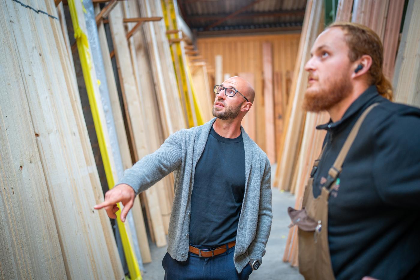 Jan-Hendrik Koch im Gespräch mit einem Mitarbeiter im Holzlager