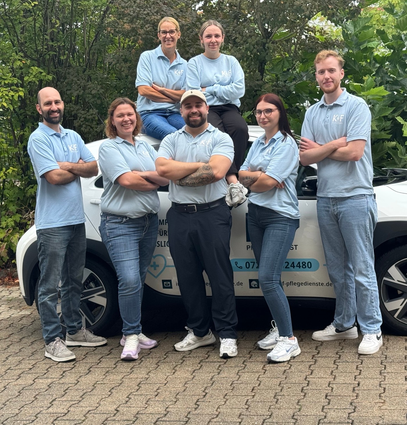 Das Team von K&F Pflegedienste vor dem Firmenfahrzeug