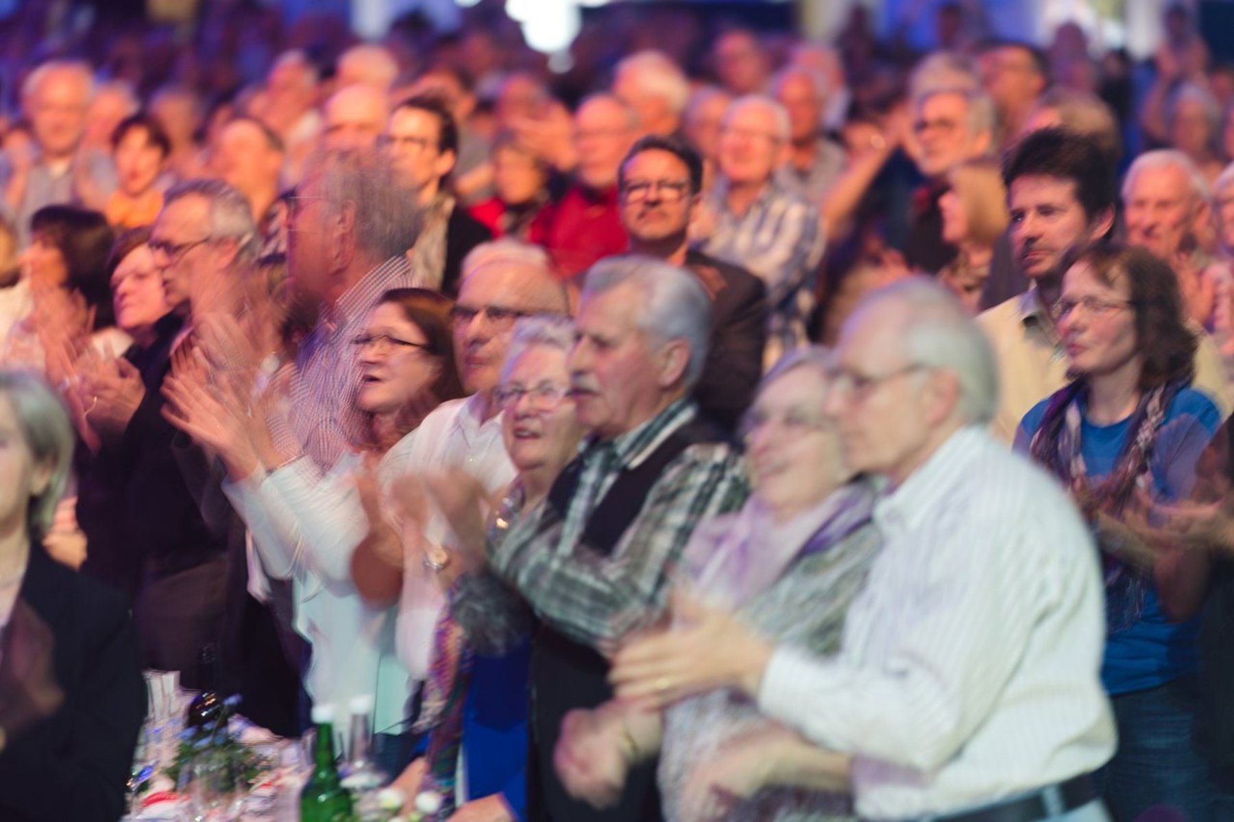 Generalversammlung der Raiffeisenbank Zürcher Oberland: Mitglieder stehen auf und applaudieren, fotografiert von Eventfotograf Alex Lörtscher