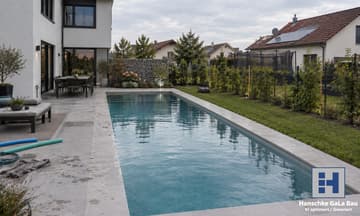 Langes Schwimmbecken mit Natursteinterrasse an einem modernen Wohnhaus