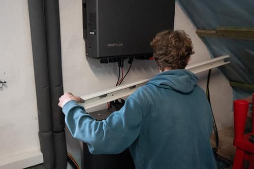 Techniker montiert einen Kabelkanal unter einem EcoFlow-Wechselrichter im Technikraum