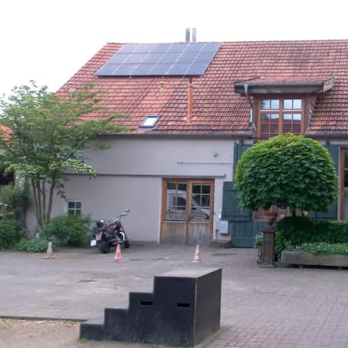 Hof mit rotem Ziegeldach und Solarmodulen