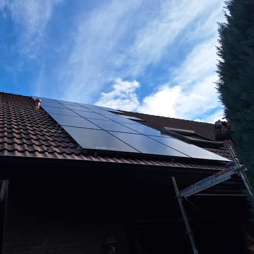 Satteldach mit Solarmodulen vor blauem Himmel