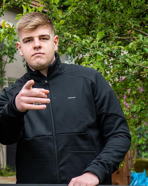 David Peters, Geschäftsführer von OurSun Solar, in der Firmenjacke im Garten