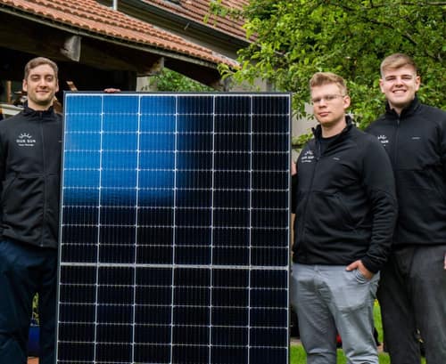 Das Team von OurSun Solar mit einem Solarmodul