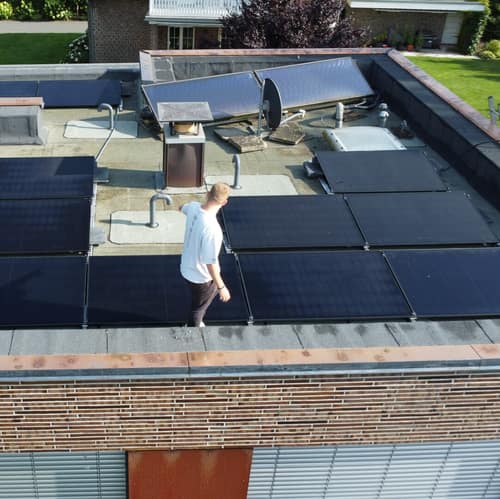 Techniker prüft eine Photovoltaikanlage auf einem Flachdach