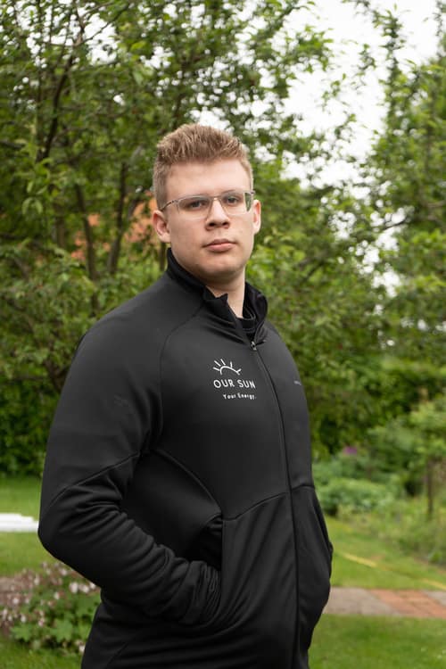 Jona Pakebusch, Geschäftsführer von OurSun Solar, in der Firmenjacke im Garten