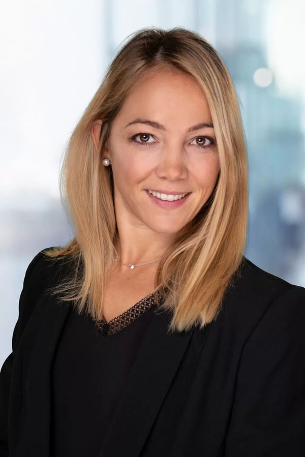 Bewerbungsfoto mit hellem Hintergrund: Frau mit langen blonden Haaren in schwarzem Blazer