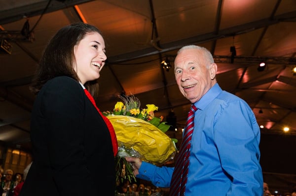 Blumen für ein langjähriges Mitglied an einer Generalversammlung, beide strahlen