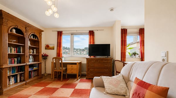 Wohnzimmer der Ferienwohnung Ausblick Spessart mit Sofaecke, Fernseher und großem Fenster