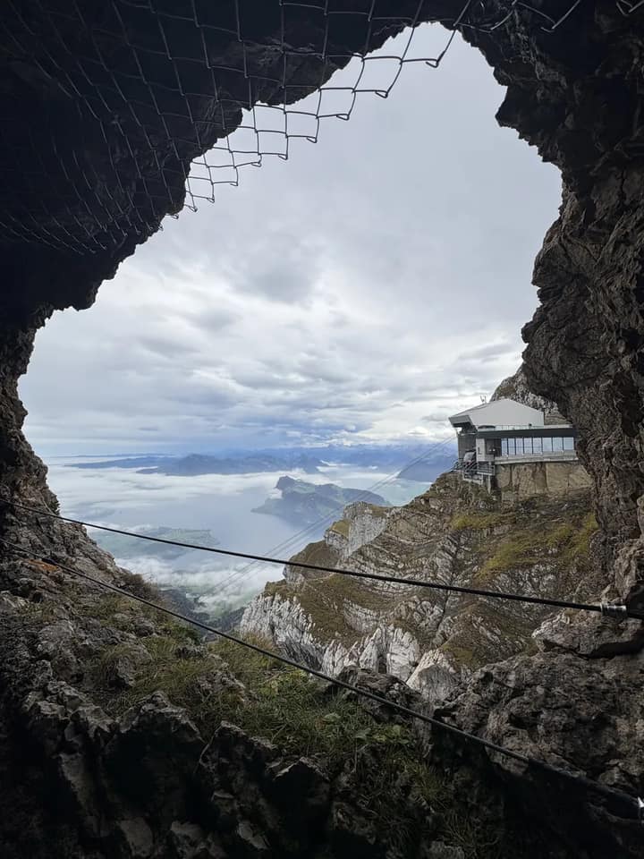 Blick durch eine Felsöffnung auf Berge und eine weite Landschaft