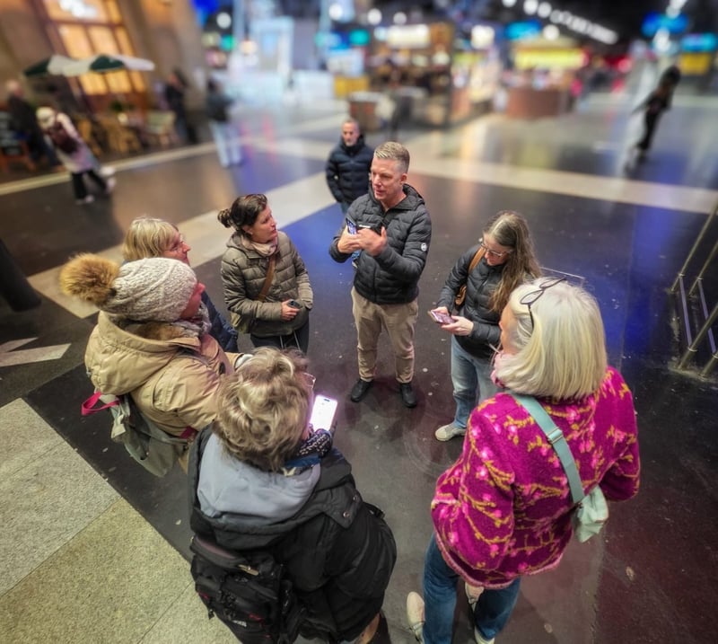 Gruppe fotografiert gemeinsam in einer Bahnhofshalle mit dem Handy
