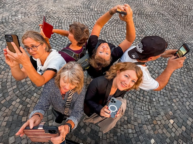 FotoWalk-Gruppe von oben fotografiert, alle schauen mit dem Smartphone nach oben
