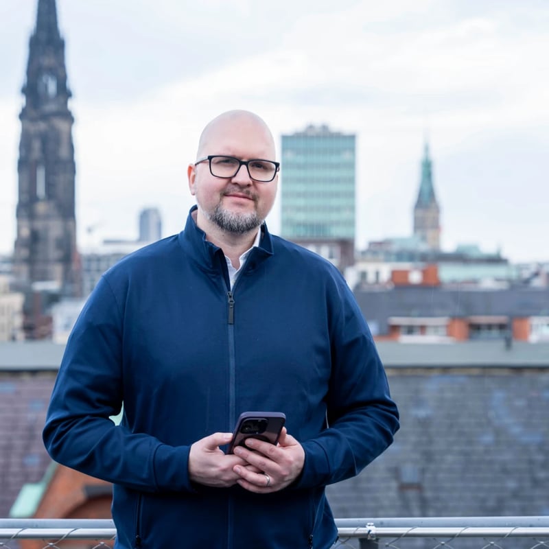 Florian Lapiz auf einer Dachterrasse in Hamburg, Kirchtürme im Hintergrund