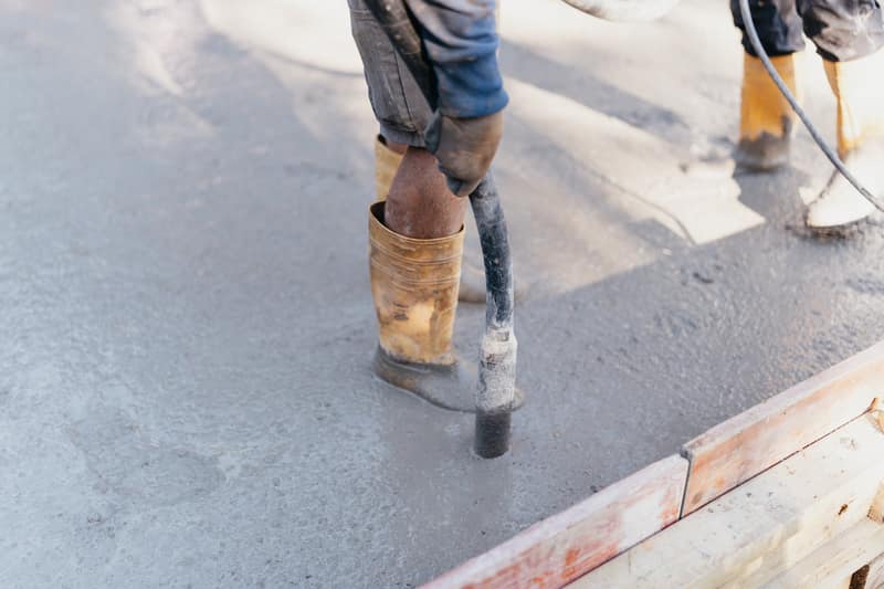 Mitarbeiter verdichten den Beton für einen Anbau in Much