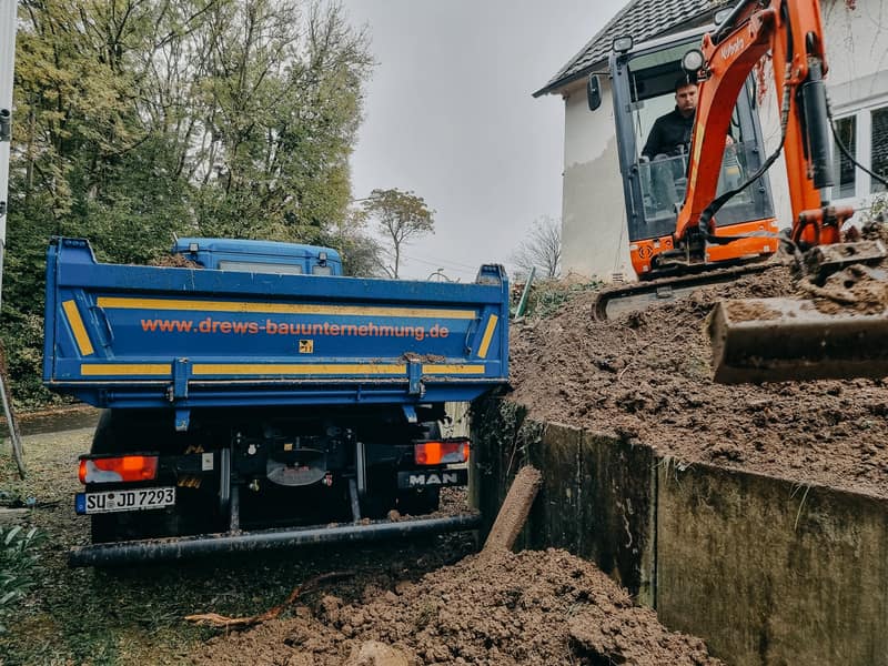 Lkw und Bagger der Bauunternehmung Drews an der Grundschule in Much