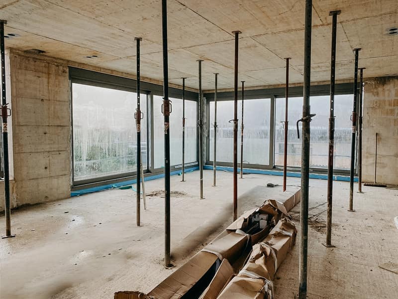 Rohbau-Innenraum mit Deckenstützen und großen Fensteröffnungen eines Neubaus in Rösrath