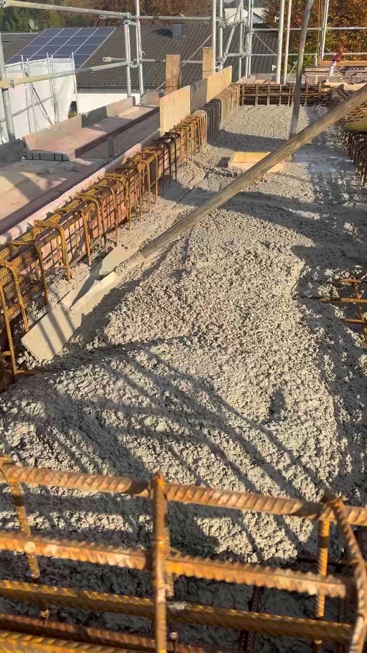 Frischer Beton wird zwischen die Bewehrung einer Decke eingebracht