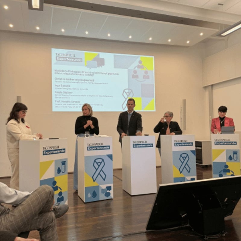 Mehrere Personen sitzen mit Mikrofonen bei einer Podiumsdiskussion am Tisch.