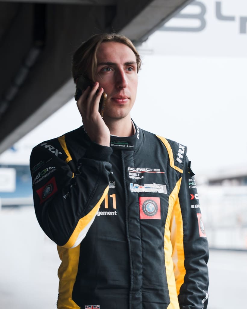 Rennfahrer von Gus Burton Racing im Rennanzug in der Box