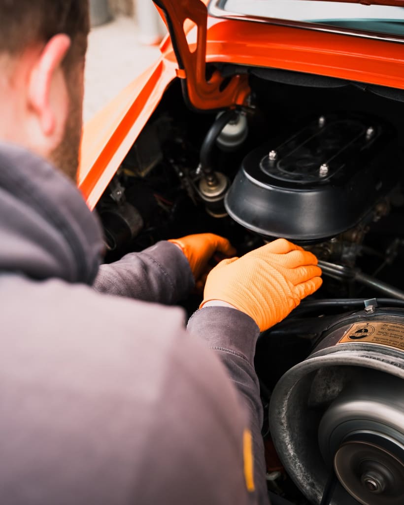 Mechaniker arbeitet am Motor eines klassischen Porsche 911