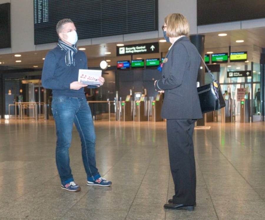 Alex Lörtscher mit Schutzmaske und Fotobuch im menschenleeren Terminal des Flughafens Zürich während der Corona-Pandemie