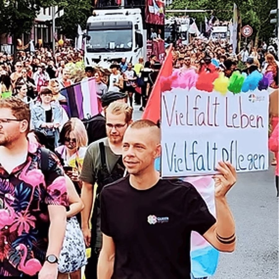 Teilnehmende einer CSD-Demonstration mit einem Schild mit der Aufschrift Vielfalt leben.