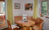 Kitchen-diner – a rustic dining area with an oval wooden table, corner bench and chairs; two pictures on the wall.