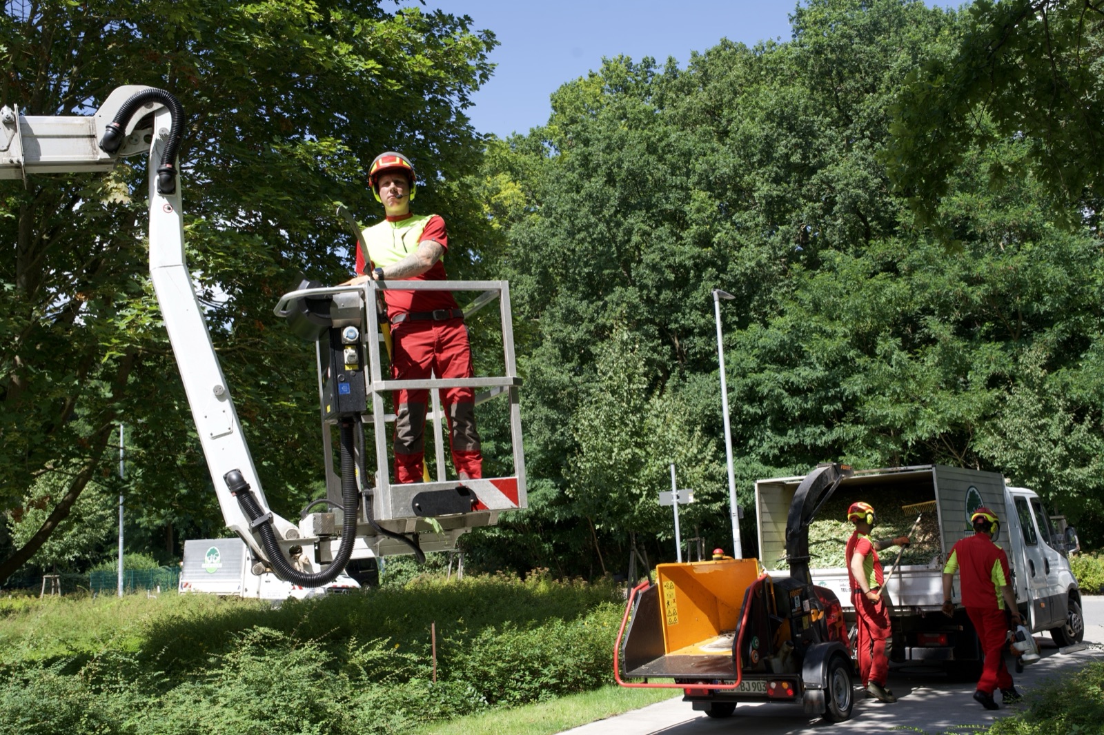 Einsatzstelle mit Hubarbeitsbühne, Häcksler und beladenem Transporter