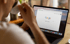 Eine Person trinkt Kaffee und verwendet einen Laptop mit geöffneter Google-Suchseite.