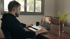 Homem em home office participando de uma videochamada no laptop sobre uma mesa de madeira – trabalhando na Alemanha