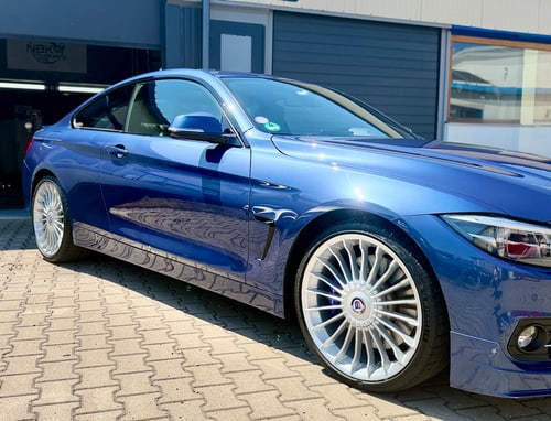 BMW in Blau vor der Werkstatt